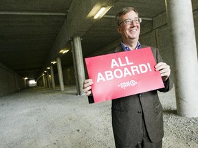 Ottawa Mayor Jim Watson stands in an LRT tunnel at Algonquin College holding an "All Aboard" sign during a media event to announce the request to federal and provincial governments for funding for the next stage of light rail on Thursday July 9, 2015.