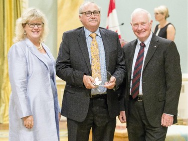 Paul Mills from Atlantic Canada Opportunities Agency , center, receives the Public Service Award of Excellence for Outstanding Career from Janice Charette, clerk of the privy council, left, and David Johnston, Governor General of Canada, right, at Rideau Hall Wednesday September 16, 2015. (Darren Brown/Ottawa Citizen) - Assignment 121627