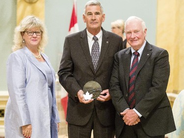 Peter L. Estey from Canada Revenue Agency, center, receives the Public Service Award of Excellence for Management Excellence from Janice Charette, clerk of the privy council, left, and David Johnston, Governor General of Canada, right, at Rideau Hall Wednesday September 16, 2015. (Darren Brown/Ottawa Citizen) - Assignment 121627