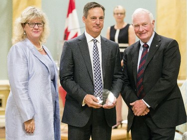 Peter Larose from Employment and Social Development Canada, center, receives the Public Service Award of Excellence for Management Excellence from Janice Charette, clerk of the privy council, left, and David Johnston, Governor General of Canada, right, at Rideau Hall Wednesday September 16, 2015. (Darren Brown/Ottawa Citizen) - Assignment 121627