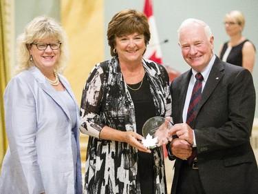 Rachel Corneille Gravel of Veterans Affairs Canada receives the Public Service Award of Excellence for Outstanding Career from Janice Charette, clerk of the privy council, left, and David Johnston, Governor General of Canada, right, at Rideau Hall Wednesday September 16, 2015. (Darren Brown/Ottawa Citizen) - Assignment 121627