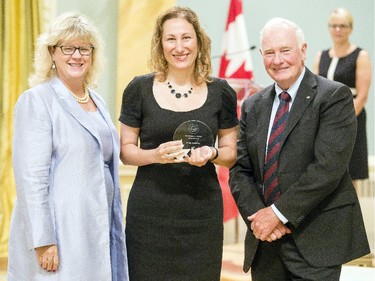 Roula Eatrides from Courts Administration Services, center, receives the Public Service Award of Excellence for Management Excellence from Janice Charette, clerk of the privy council, left, and David Johnston, Governor General of Canada, right, at Rideau Hall Wednesday September 16, 2015. (Darren Brown/Ottawa Citizen) - Assignment 121627