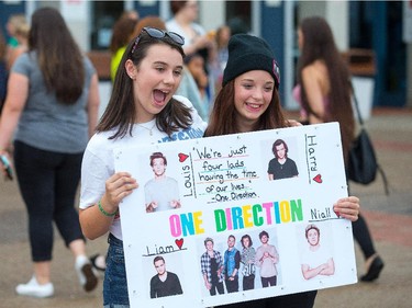 Roxane Saulnier, 13, and Mackenzie Lamontagne, 13, from Kingston pose with their sign as the band One Direction takes to the stage at Canadian Tire Centre on Tuesday night.