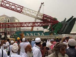 Muslim pilgrims gather in front the crane that collapsed the day before at the Grand Mosque in Saudi Arabia's holy Muslim city of Mecca on September 12, 2015. This year's Muslim Hajj pilgrimage will go ahead despite a crane collapse which killed more than 100 people at the Grand Mosque of Mecca, a Saudi official told AFP.
