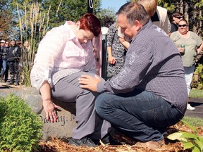 Ted Kent, owner of Kent Construction, consoles an emotional Sharlene Pietersma as she touches the name of her late husband, Danny, engraved on a stone in front of her new home. More than two years after an intruder took her husband's life, Pietersma returned to the address to find a new house built by the generosity of businesses, donors and volunteers from around the community of Petawawa.