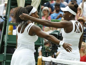 Serena Williams of the United States, left hugs her sister Venus Williams of the United States after winning their singles match, at the All England Lawn Tennis Championships in Wimbledon, London, Monday July 6, 2015. Serena Williams won 6-4, 6-3.