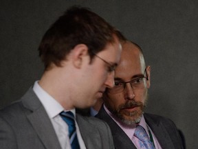 NDP Leader Tom Mulcair's director of communications Shawn Dearn, right, speaks with George Smith, Executive & Media Assistant to the Leader on the sidelines of a news conference by Mulcair (not pictured) on Parliament Hill in Ottawa on Wednesday, February 18, 2015.