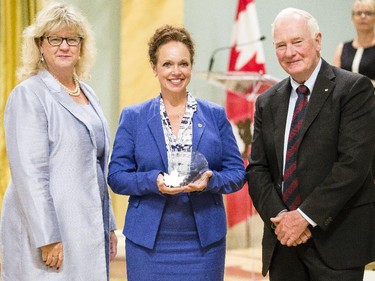 Sherry Sharpe of the Canada Revenue Agency receives the Public Service Award of Excellence in Official Languages on behalf of the National Committee of Champions of Official Languages from Janice Charette, clerk of the privy council, left, and David Johnston, Governor General of Canada, right, at Rideau Hall Wednesday September 16, 2015. (Darren Brown/Ottawa Citizen) - Assignment 121627