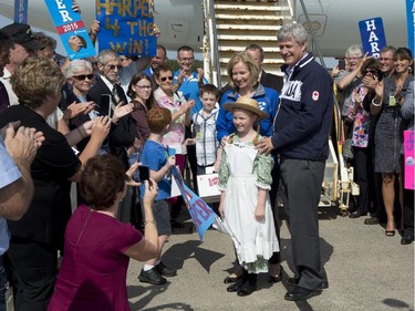 Conservative Leader Stephen Harper  and wife Laureen pose for a photo with a young girl dressed as Anne of Green Gables as they depart Charlottetown, P.E.I., on Thursday, September 10, 2015.