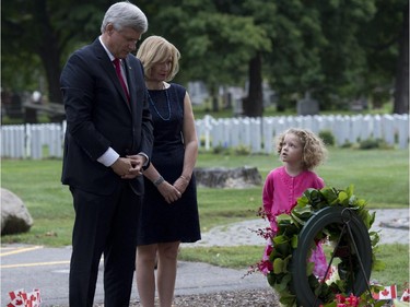 Sara Vulin Daniel, right, in pink, looks up towards Conservative Leader Stephen Harper and wife Laureen  as they lay a wreath to honour Canadian victims of the 9/11 terrorist attacks on Friday, September 11, 2015, in Ottawa.