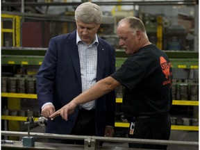 Conservative Leader Stephen Harper speaks with Lloyd Crooks as he tours a steel factory during a campaign stop in Burlington, Ont., on Tuesday, September 1, 2015.
