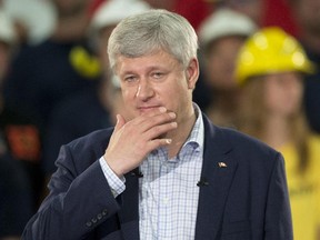 Conservative leader Stephen Harper  listens to a question from the media during a campaign stop at a steel manufacturer in Burlington, Ont., on Tuesday, September 1, 2015.