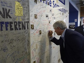 Conservative Leader Stephen Harper signs the wall at Facebook during a campaign stop in Toronto, Tuesday September 8, 2015..