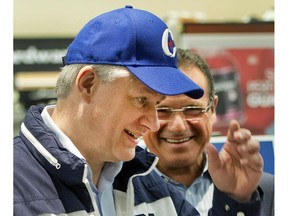 Conservative leader Stephen Harper tries on a Conservative party cap while campaigning at a hardware show Monday, September 21, 2015  in St. Jacobs, ON..THE CANADIAN PRESS/Ryan Remiorz