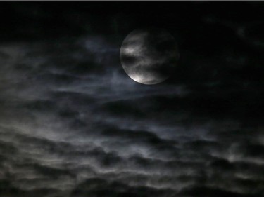 Clouds obscure the so-called supermoon before a lunar eclipse Sunday, Sept. 27, 2015, in Chicago. It's the first time the events have made a twin appearance since 1982, and they won't again until 2033.