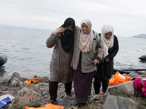 Syrian refugees arrive on the shores of the Greek island of Lesbos after crossing the Aegean sea from Turkey on an inflatable dinghy , Wednesday, Sept. 23, 2015.