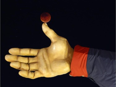 The so-called supermoon appears during a lunar eclipse behind Big Tex, Sunday, Sept. 27, 2015, at the State Fair of Texas at Fair Park in Dallas. It was the first time Sunday that the events have made a twin appearance since 1982, and they won't again until 2033.