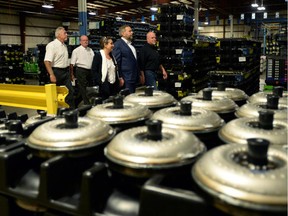 NDP Leader Thomas Mulcair and wife Catherine Pinhas walk past engine torque converters as they make a campaign stop at an auto parts manufacturing plant in Niagara Falls, Ont., on Wednesday, September 9, 2015.