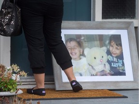 A woman arrives at the home of Tima Kurdi with a photo of her nephews Alan, left, and Ghalib Kurdi, in Coquitlam, B.C., on Thursday September 3, 2015.