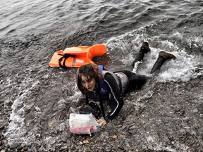 A Syrian refugee arrives on the shore of the Greek island of Lesbos, after crossing the Aegean sea from Turkey, on Monday.