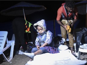 A child waits as refugees prepare to board a boat to reach the Greek Island of Kos from Turkish side Bodrum early on August 20, 2015.