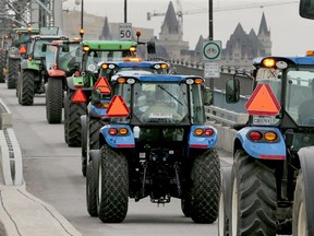 Tractors roll across the Alexandria Bridge, from Quebec to Ottawa, en route to Parliament Hill Tuesday, September 29, 2015.