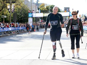 Triple amputee Bryan Cuerrier (L) and Marie Andree Paquin (R) participate in the Half Marathon during the 2015 Canada Army Run in Ottawa on September 20, 2015.