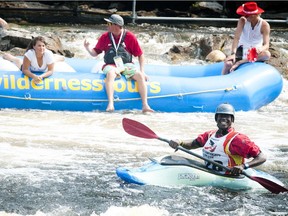 Ugandan Sadat Kawawa gets cheered on by the crowd before hitting the garburator wave during the kayak freestyle championships near Ottawa.