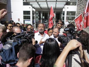 Unifor Local 1688 President Amrik Singh and other demonstrators are scrummed by media after a meeting with Acting Deputy City Manager Sue Jones during an anti-Uber protest by Ottawa taxi drivers in front of city hall on Sept. 16, 2015.