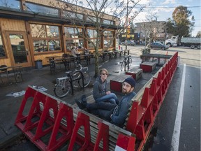 Adam Fink and Robbie Slade sit in a parklet  in Vancouver in 2013. Ottawa's transportation committee has approved a trial of similar parking-spot conversions.