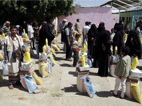 Yemenis receive food aid from a Yemeni philanthropist who provides aid parcels to families affected by the ongoing conflict between loyalist forces and Huthi rebels, on September 15, 2015, in the capital Sanaa. The United Nations says nearly 4,900 people have been killed and some 25,000 wounded since late March, while 21 million out of Yemen's population of 25 million have been affected by the conflict.