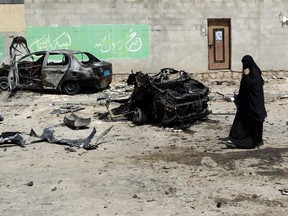 Yemenis walk on June 18, 2015 near the wreckage of cars after five simultaneous bombings targeting Shiite mosques and offices hit the Yemeni capital Sanaa the previous night killing at least 31 people. The Islamic State group, a Sunni Muslim radical group, said the attacks were in "revenge" against the Shiite Huthis, who have overrun Sanaa and much of the Sunni majority country and whom it considers to be heretics.
