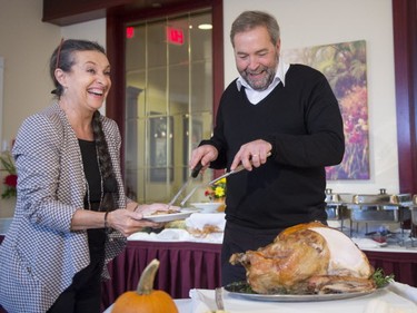 NDP leader Tom Mulcair and his wife, Catherine carve up a turkey for Thanksgiving on Sunday, October 11, 2015 in Courtenay, B.C. THE CANADIAN PRESS/Ryan Remiorz