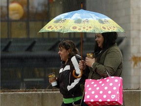 A picturesque umbrella protects two women from a downpour as they walk along Rideau St. near Sussex Dr. Wednesday May 28, 2015.