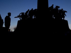 A soldier stands guard at dusk at the National War Memorial on Friday, October 24, 2014.