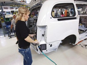 A worker on the production line at Chrysler's assembly plant in Windsor, Ontario, works on one of their new minivans, in this file shot. T