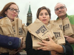 Anti-poverty activists Darlene O'Leary, Leilani Farha and Joe Gunn joined election candidates and volunteers to distribute  apples in "Chew on This" bags at Parliament Hill Tuesday.