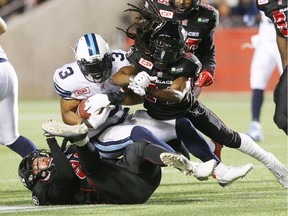 Brandon Whitaker (3) of the Toronto Argonauts is tackled by #14 Abdul Kanneh and Justin Capicciotti (L) of the Ottawa Redblacks during first half of CFL action at TD Place in Ottawa, October 06, 2015. (Jean Levac/ Ottawa Citizen)