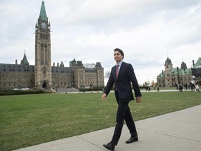 Prime minister-designate Justin Trudeau strolls past Parliament the day after his big victory.
