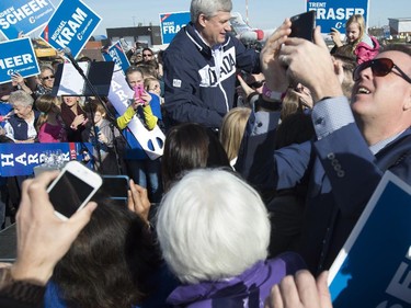Conservative Leader Stephen Harper greets supporters during a campaign rally on the airport tarmac in Regina,  Sunday, Oct. 18, 2015.  Canadians will go to the polls in the federal election Oct. 19.