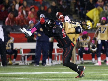 David Hinds of the Ottawa Redblacks tackles Nick Moore of the Winnipeg Blue Bombers during first half CFL action.
