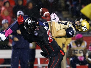 David Hinds of the Ottawa Redblacks tackles Nick Moore of the Winnipeg Blue Bombers during first-half CFL action.