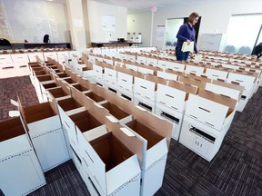 Elections Canada employee Stephanie Haskey fills ballot boxes with polling station materials in preparation for Monday's federal election, in southeast Calgary.