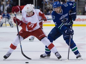 The Detroit Red Wings don't usually rush their prospects to the NHL, but Dylan Larkin, seen in a file photo taking the puck from the Vancouver Canucks' Radim Vrbata, made it an easy decision to keep him in the NHL this season.