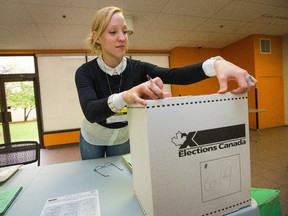 Election worker Katie Dudzik closes up a ballot box while helping to prepare for voters as advance polls for the Oct. 19 federal election open.