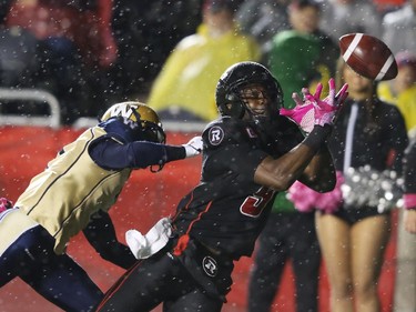 Ernest Jackson of the Ottawa Redblacks stretches out but can't handle a pass into the end zone as he is taken down by  Demond Washington of the Winnipeg Blue Bombers.