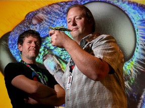 Exhibit technician, Stuart Baatnes, holds a Malaysian Jungle Nymph, Dan Boivin, the project manager for the show, looks on.