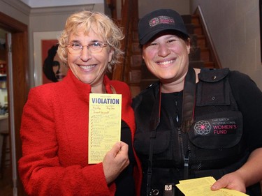 From left, Roslyn Bern, president of the Leacross Foundation, was a good sport after Erin Edwards issued her a violation ticket as part of an awareness-raising gimmick for The Match International's Women Fund reception, held Wednesday, October 28, 2015.