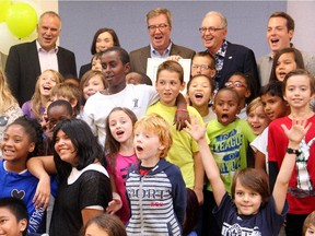From top left, Rideau-Rockcliffe Ward Coun. Tobi Nussbaum, BGC executive director Colleen Mooney, Mayor Jim Watson, BGC board chair Graham Macmillan and Rideau-Vanier Ward Counc. Mathieu Fleury, got help from a happy group of kids during the City of Ottawa's presentation of a framed certificate at the grand re-opening of the Don McGahan Clubhouse in Vanier on Wednesday, September 30, 2015.