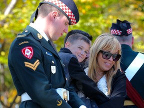 Cpl. Branden Stevenson, Marcus Cirillo and Natasha Cirillo share a moment during the unveiling of a plaque honouring Nathan Cirillo following the main ceremony at the National War Memorial. 
Stevenson was Nathan Cirillo's sentry partner on that fateful morning one year ago. Marcus is Nathan's son and Natasha is his sister.